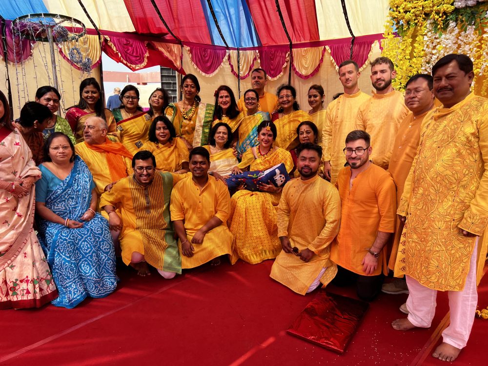 Group in yellow and red for Giulia and Deep's Haldi Ceremony.